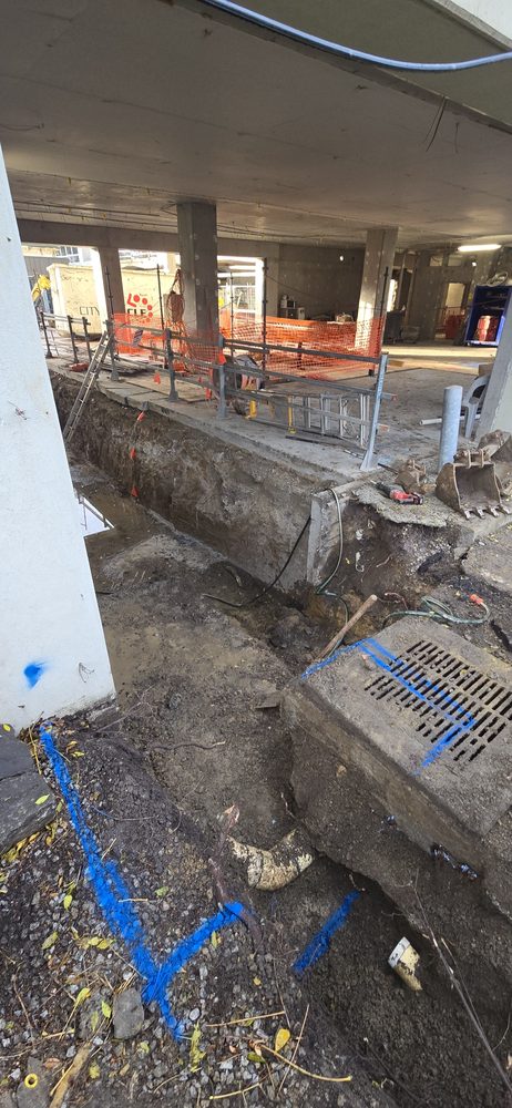 Structural excavation and services trench beneath a commercial building under construction