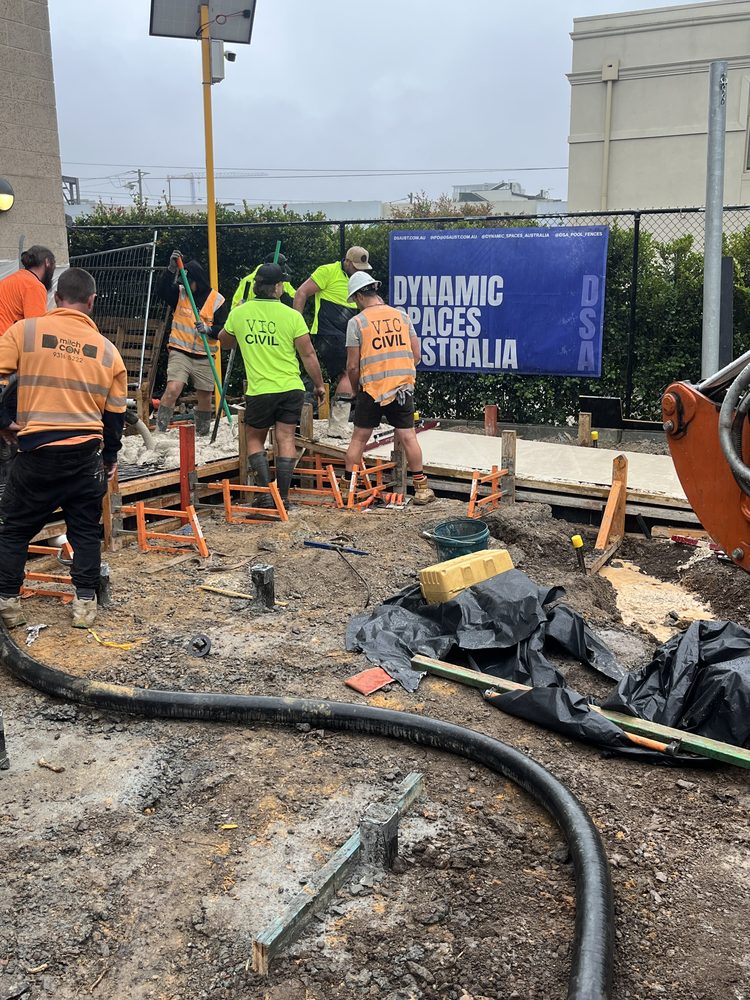 Construction crew forming steel-reinforced concrete footings on a commercial civil works site