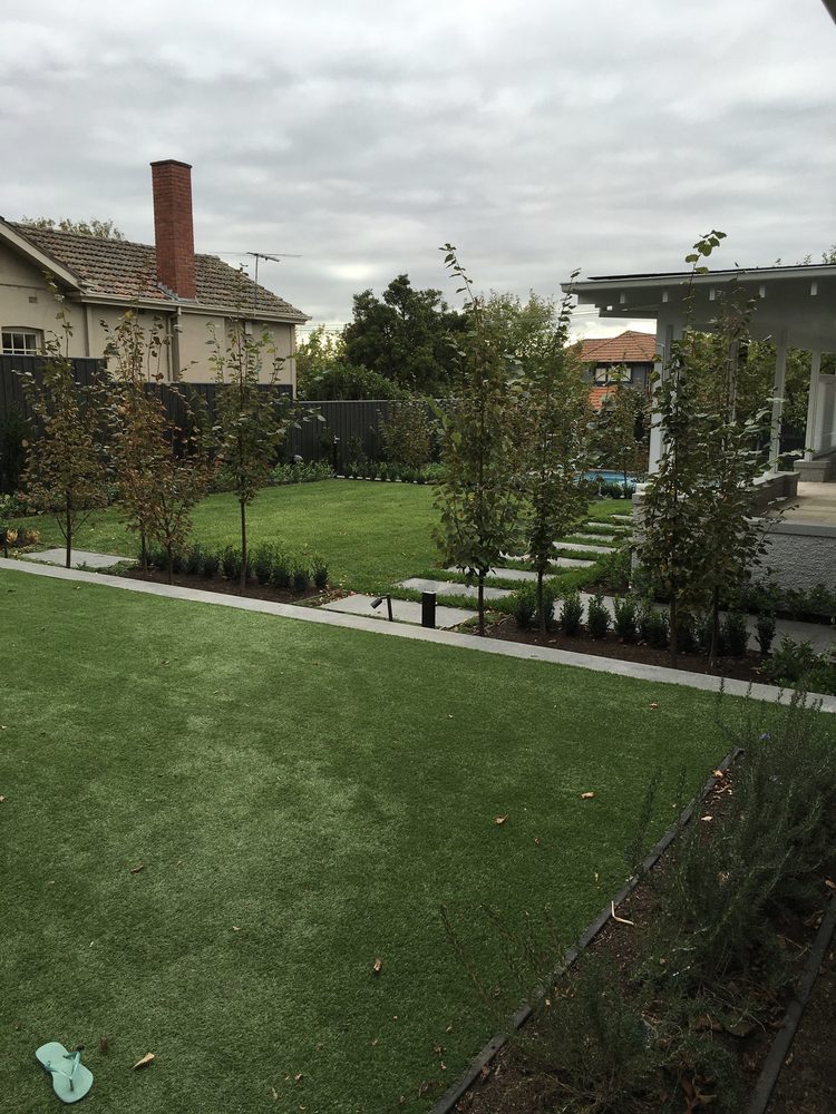 Landscaped backyard with lawn, ornamental pear trees and bluestone stepping stones