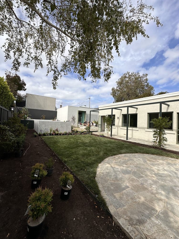 Backyard landscape installation with new turf, potted plants and a crazy-paved patio