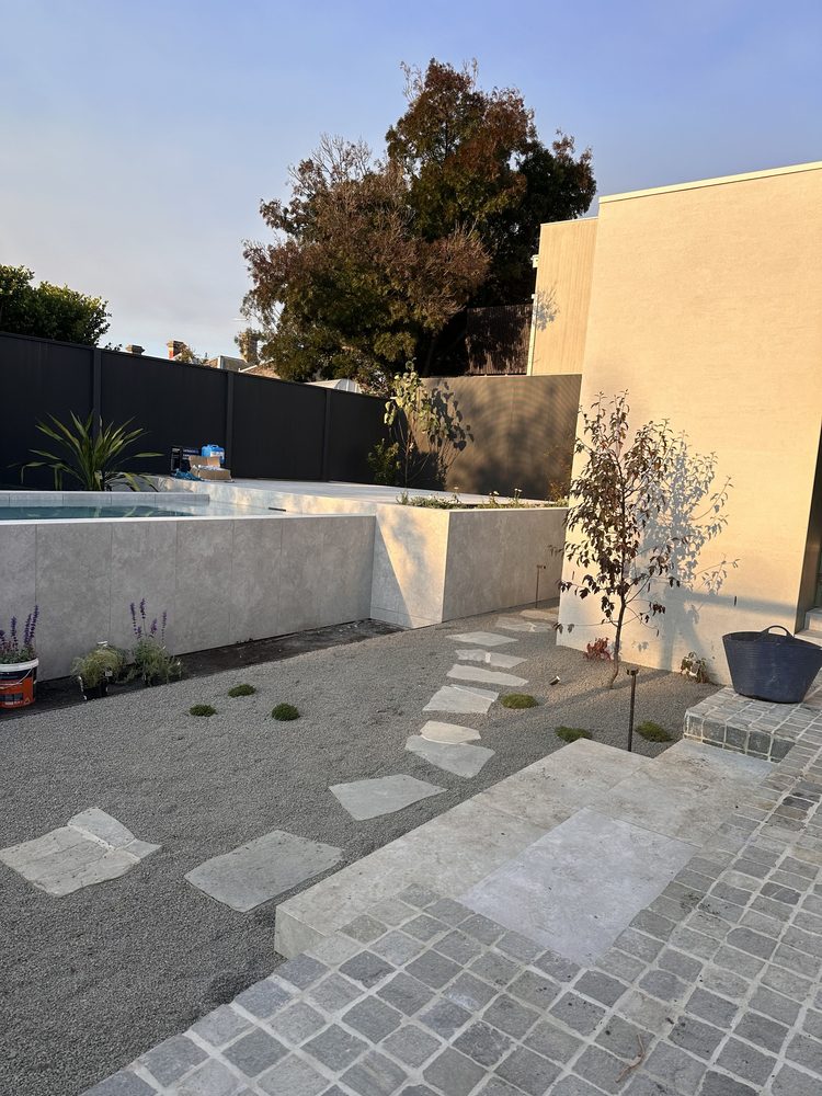 Landscaped courtyard with a raised plunge pool and natural stone paving