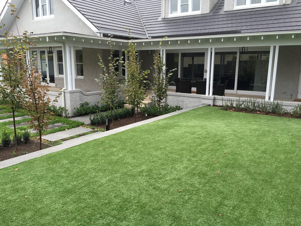 New lawn, bluestone paving and garden beds beside a rendered period home