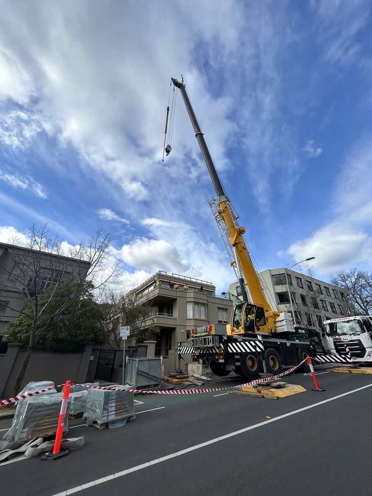 Mobile crane lifting materials onto a building during a civic construction project