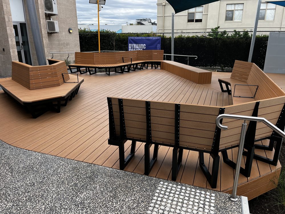 Composite timber deck with bench seating and stainless steel handrails in a civic space