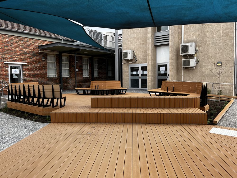 Tiered composite deck and bench seating outside a community building
