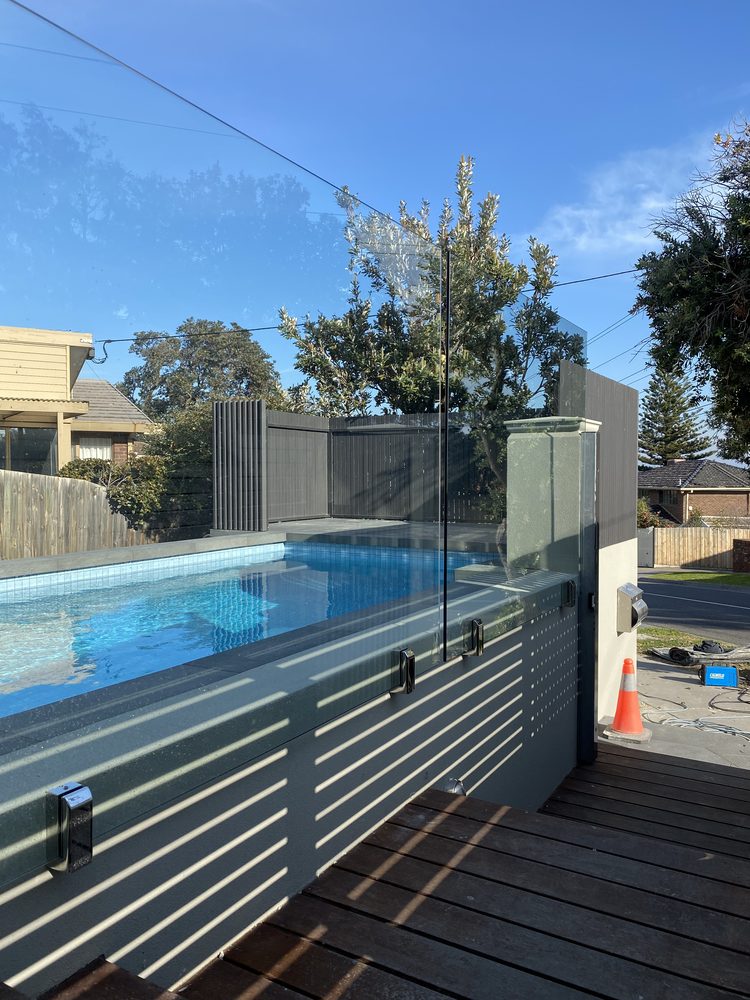 Black aluminium batten pool fence around a lap pool at a heritage home