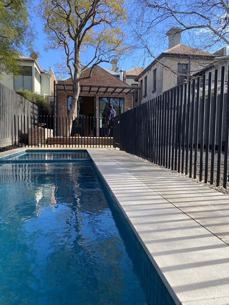 Frameless glass fence around a round spa pool set into a timber deck